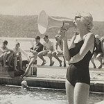 Black and white photo of a woman in a swimming costume with a megaphone